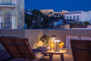 un tavolo e due sedie su un balcone di notte di Moon And Stars Athens ad Atene