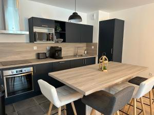 a kitchen with a wooden table and some chairs at L'Aumonerie in Angers