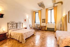 1 dormitorio con 2 camas, mesa y sillas en Albergo San Giovanni en Florence