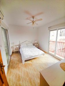 een witte slaapkamer met een bed en twee ramen bij Villa Casa Max - duplex-apartment in Villamartin Golf Resort in Villamartin +19 foto's