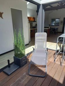 una silla blanca y una maceta en una cubierta en Maison ambiance loft à 2 pas du port d'Arcachon et des plages, en Arcachon