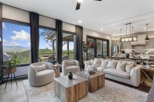 a living room with a couch and chairs and a kitchen at High Meadow Retreat in Boone