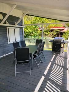 eine Terrasse mit einem Tisch, Stühlen und einem Grill in der Unterkunft Domek na Mazurach 