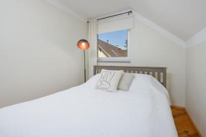 1 dormitorio con 1 cama blanca y ventana en Kooli Apartment, en Pärnu
