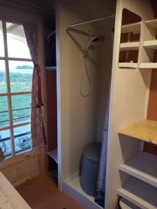 a walk in closet in a tiny house with a window at Véritable roulotte hippomobile "LA BAILLEUL" in Mentheville