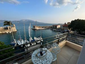a balcony with a table and chairs and boats in the water at Vip Lepanto Port Suites in Nafpaktos