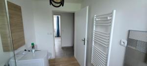 a white bathroom with a sink and a washing machine at Les Geais Bleus in Royan