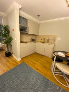 a kitchen with white cabinets and a table in a room at Apartamentos Colmeia in Lisbon