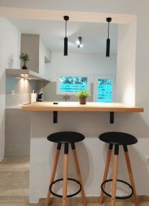 a kitchen with two bar stools at a counter at Josephine's place in Tinos +8 photos