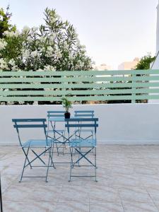 two chairs and a table with a potted plant on a patio at Josephine's place in Tinos