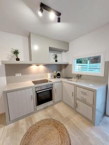 a kitchen with white cabinets and a sink and a window at Josephine's place in Tinos