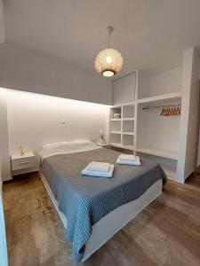a bedroom with a large bed with a blue blanket at Josephine's place in Tinos