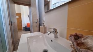 un baño con lavabo y espejo en Appartamento Tharros, en Cabras 23 fotos más