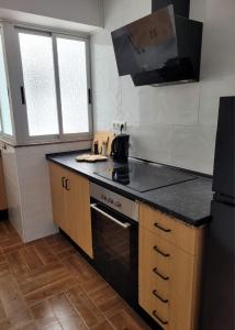 a kitchen with a stove and a black counter top at Bella Vista in Piles +6 photos