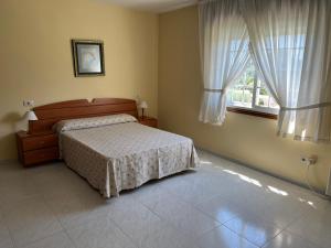1 dormitorio con cama y ventana en Apartamentos Rial, en Sanxenxo