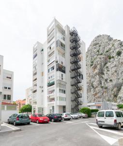 a parking lot with cars parked in front of a building at Apartment Zdravka in Omiš