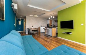 a living room with a blue couch and a green wall at Apartment Zdravka in Omiš