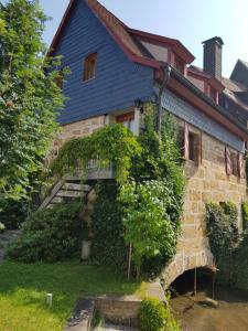 ein Haus mit blauem Dach und Efeu in der Unterkunft Wagners Fränkischer Hof in Altenkunstadt