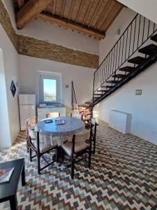 a living room with a table and a spiral staircase at Monti D'Abruzzo holiday home in Crecchio