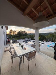 a patio with a table and chairs and a pool at VILLA avec PISCINE PRIVÉE NON PARTAGÉE in Camps-la-Source
