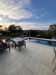 a swimming pool with chairs and a patio with a view at VILLA avec PISCINE PRIVÉE NON PARTAGÉE in Camps-la-Source