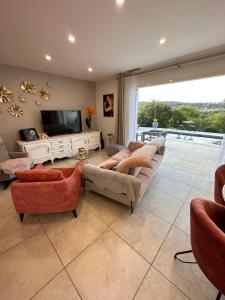 a living room with couches and a flat screen tv at VILLA avec PISCINE PRIVÉE NON PARTAGÉE in Camps-la-Source