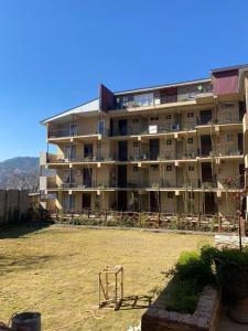 un gran edificio de apartamentos con un campo delante en SK Lounges Bhurban, en Bhurban