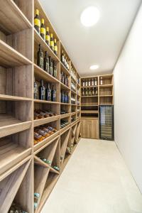 a wine cellar with wooden shelves and wine bottles at Villa Dono in Sutivan