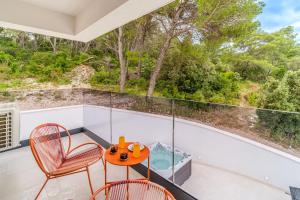 a room with a balcony with two chairs and a table at Villa Dono in Sutivan