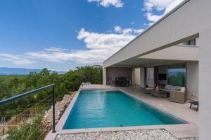 a swimming pool on the balcony of a house at Villa El Viento in Šmrika