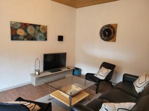 een woonkamer met een bank en een glazen tafel bij Ferienhaus im Moseltal in Bruttig-Fankel