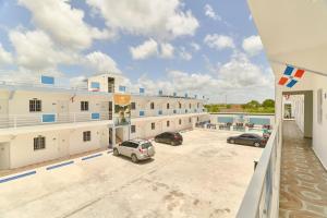 a large building with cars parked in a parking lot at Costa Love Aparta Hotel in Punta Cana