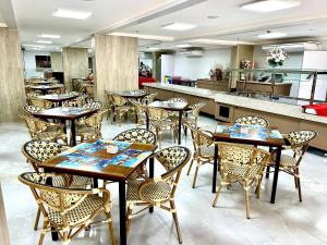 un restaurante con mesas y sillas en una habitación en Spazzio Di Roma - Apartamentos para Temporada en Caldas Novas