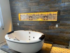 Pousada Vila de Charme في باريرينهاس: حوض استحمام في الحمام بجدار خشبي