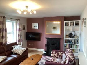 a living room with a couch and a fireplace at Island View Roundstoneselfcatering in Roundstone