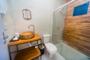 uma casa de banho com um lavatório, um WC e um chuveiro em Pousada Vila de Charme em Barreirinhas