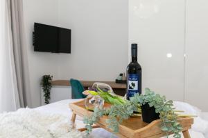 una botella de vino en una mesa de madera con plantas en Pansion Gaspar, en Biograd na Moru