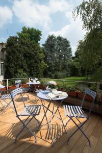 trzy krzesła i stół na drewnianym tarasie w obiekcie Hotel Tiziano - Gruppo Mini Hotel w Mediolanie
