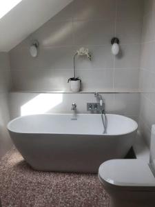 a white bath tub in a bathroom with a toilet at The Croft in Cowbridge