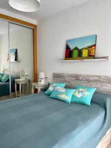 a bedroom with a bed with blue pillows at ÁTICO Paraíso Beach con piscina privada in Vera