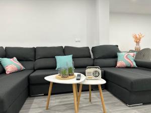 een woonkamer met een bank en een tafel met een klok bij Estadio playa in Almería