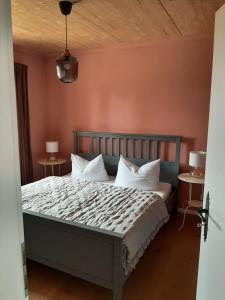 a bedroom with a bed with white pillows at Landliebe, Ferienhaus, 3 Schlafzimmer mit Sauna und Outdoor Whirlpool in Geierswalde