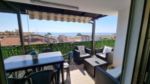 d'un balcon avec une table et des chaises et une vue. dans l'établissement Blue Horizon Calabria - Seaside Apartment 120m to the Beach - Air conditioning - Wi-Fi - View - Free Parking, à Santa Caterina Dello Ionio Marina