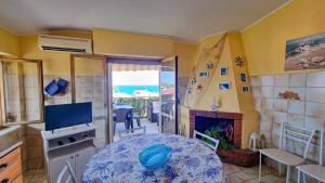 een woonkamer met een tafel en een open haard bij Blue Horizon Calabria - Seaside Apartment 120m to the Beach - Air conditioning - Wi-Fi - View - Free Parking in Santa Caterina Dello Ionio Marina