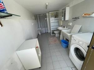 y baño pequeño con lavadora. en Casa Tullo, en San Costanzo