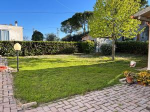 een tuin met een groen gazon met een boom erin bij Casa Tullo in San Costanzo