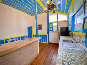 um quarto com paredes azuis e amarelas e um lavatório em Casa Colonial Salento em Salento