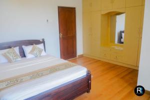 a bedroom with a bed and a dresser with a mirror at Royal Residency in Kandy