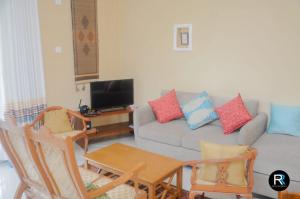 sala de estar con sofá, mesa y sillas en Royal Residency en Kandy