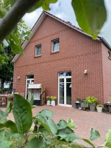 un bâtiment en briques rouges avec un banc devant lui dans l'établissement Landhaus "Alte Welt" Nordseeküste, à Osteel